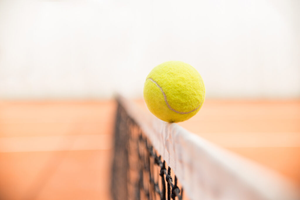 Tennisball auf der Netzkante